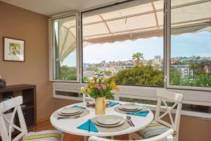 comedor con mesa, sillas y ventana en Sea View 2 Mins Walk To Beach And Estoril Casino en Estoril