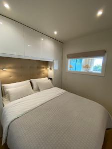 Sea View 2 Mins Walk To Beach And Estoril Casino في استوريل: غرفة نوم مع سرير أبيض كبير مع نافذة