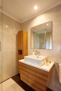 a bathroom with a white sink and a mirror at Sea View 2 Mins Walk To Beach And Estoril Casino in Estoril