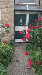 een deur met rode rozen voor een gebouw bij Beautiful and peaceful large double bedroom near Olympic Park in Stratford London in Londen