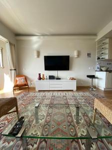 sala de estar con TV de pantalla plana en la pared en Sea View 2 Mins Walk To Beach And Estoril Casino en Estoril