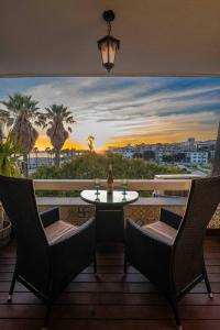 Sea View W Balcony 2 Mins Walk To Beach & Casino في استوريل: شرفة مع طاولة وكراسي وإطلالة على المحيط