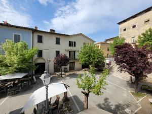 a woman sitting at a table in front of a building at Casa in Piazza in Asciano