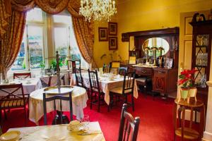 a dining room with tables and chairs and a chandelier at Innisfree House in Dundalk