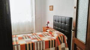 um quarto com uma cama e um candeeiro sobre uma mesa em 3 bedrooms apartement with city view balcony and wifi at Cadiz em Cádiz