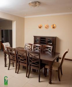 uma sala de jantar com uma mesa de madeira e cadeiras em Su's Crest em Blantyre