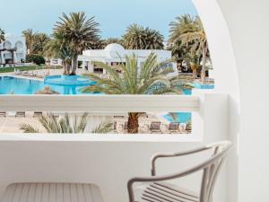 a view of the pool from the balcony of a resort at Hotel Bougainvillier Djerba in Taguermess