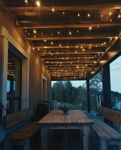 un patio con una mesa de madera con luces. en Brīvdienu māja Dinary en Dagda