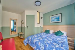 1 dormitorio con 1 cama con edredón azul en LE PADIRAC, en París