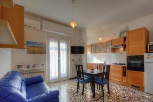 a living room with a blue couch and a table at A Gonfie Vele VADOALMARE Immobiliare in Vado Ligure