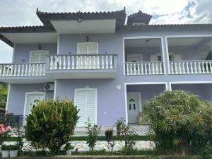 a purple house with a balcony on top of it at Katerina's Relaxing Apartment in Sarandë
