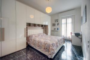 a bedroom with a bed and a large white cabinet at A Gonfie Vele VADOALMARE Immobiliare in Vado Ligure