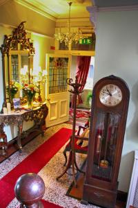 uma sala de estar com um relógio avô e uma mesa em Innisfree House em Dundalk