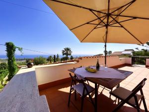 einen Tisch und Stühle mit Sonnenschirm auf einer Terrasse in der Unterkunft Casa Villea in Trabia