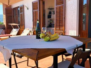 Casa Villea في ترابيا: طاولة مع وعاء من الموز واكواب النبيذ