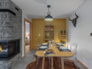 シャテルにあるLes Flambeaux - Apt B22 - BO Immobilier -Châtel - remises sur les forfaits de skis Châtel ou Portes du soleilのテーブルと暖炉のあるダイニングルーム