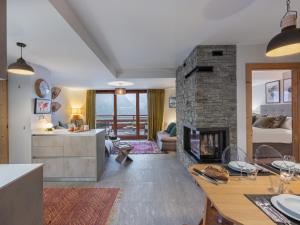 シャテルにあるLes Flambeaux - Apt B22 - BO Immobilier -Châtel - remises sur les forfaits de skis Châtel ou Portes du soleilのキッチン、リビングルーム(石造りの暖炉付)