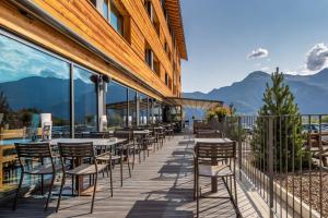 une rangée de tables et de chaises sur un balcon avec des montagnes dans l'établissement SWISSPEAK Resorts Vercorin, à Vercorin