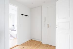 シャルロッテンルンドにあるRefurbished 1-bed in Charlottenlundの白いドアとウッドフロアの白い部屋