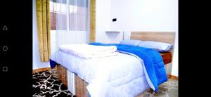 a bedroom with a bed with blue and white sheets and pillows at Airport apartment 2 