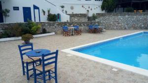 a table and chairs next to a swimming pool at Studios Avra in Akhladherí