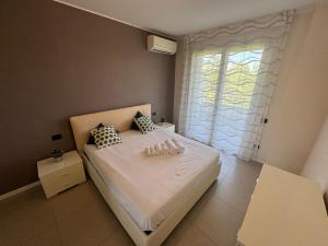 a bedroom with a bed with two pillows and a window at Via Battisti 7_Pero in Pero