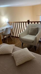 ein Schlafzimmer mit einem Sofa, einem Stuhl und einem Tisch in der Unterkunft CASA VACANZA TINDARA in Civitavecchia