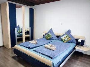 a bedroom with a bed with blue sheets and a mirror at Ferienhaus Richard in Eschwege