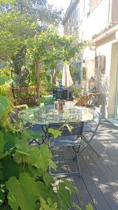een glazen tafel en stoelen op een patio bij Charmant appartement au cœur de la montagne Corse in Zoza