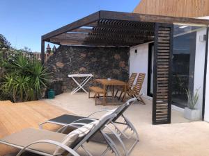 eine Terrasse mit Stühlen, einem Tisch und einer Markise in der Unterkunft Villa Calderón Hondo in Lajares