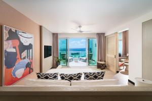 Wyndham Grand Barbados Sam Lords Castle All Inclusive Resort في سانت فيليب: غرفة بسرير وإطلالة على المحيط