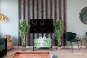un soggiorno con camino e sedie verdi di Palm Tree House - Beverly Hills Hotel a Orpington
