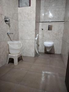 a bathroom with a toilet and a sink at Hotel Vyshak International in Mysore