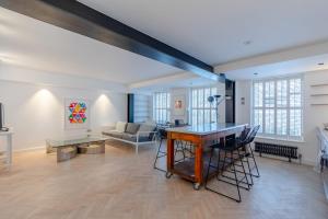 a living room with a table and a couch at Sleek & Stylish 2BD Flat - Warren Street in London
