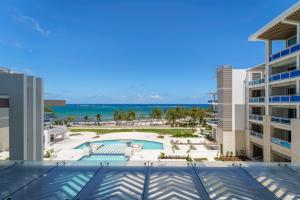 聖菲利普的住宿－Wyndham Grand Barbados Sam Lords Castle All Inclusive Resort，从大楼的阳台上可欣赏到游泳池和海洋的景色