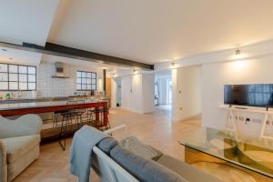 a living room with a couch and a tv at Sleek & Stylish 2BD Flat - Warren Street in London
