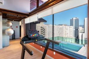 a gym with a large window with a view of the city at Lobie Casa Mauá in Rio de Janeiro