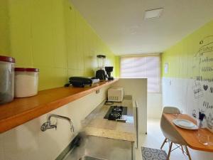 eine Küche mit Spüle und Herd in der Unterkunft LOFT aconchegante no Centro de Macaé - Wifi, Ar condicionado, tv Smart e Cozinha completa in Macaé