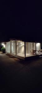 a building with two benches in front of it at night at Cosy House by the Sea in Kato Achaia