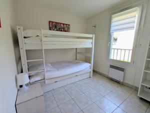 twee stapelbedden in een kamer met een raam bij Appartement avec vue sur golf in Pornic