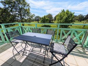 een blauwe tafel en stoelen op een terras bij Appartement avec vue sur golf in Pornic