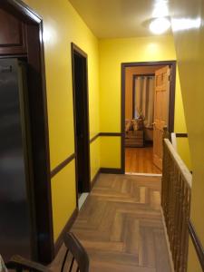 a hallway with yellow walls and a wooden floor at Room to stay in in South Ozone Park