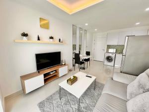 乔木提恩海滩Jungle View 1 BR in Amazon Residence的带沙发、电视和桌子的客厅