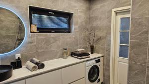 a bathroom with a washing machine and a window at Rannamaja kümblustünni & saunaga in Haapse