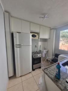 a kitchen with a white refrigerator and a stove at Apartamento araraquara in Araraquara