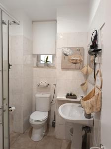 a white bathroom with a toilet and a sink at Sweet House in Lisbon