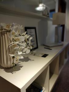 een tafel met een vaas met witte bloemen erop bij Douro View Apartment in Vila Nova de Gaia
