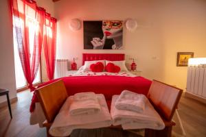 a bedroom with a bed with red sheets and a mask at Casa Rural El Capricho de Sandra in La Carrera