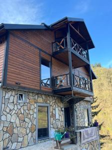 a log cabin with a balcony on top of it at Mec konaklama in Trabzon