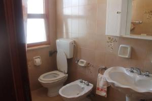 a bathroom with a toilet and a sink at Casetta Girasole a due passi dal mare in Capilungo